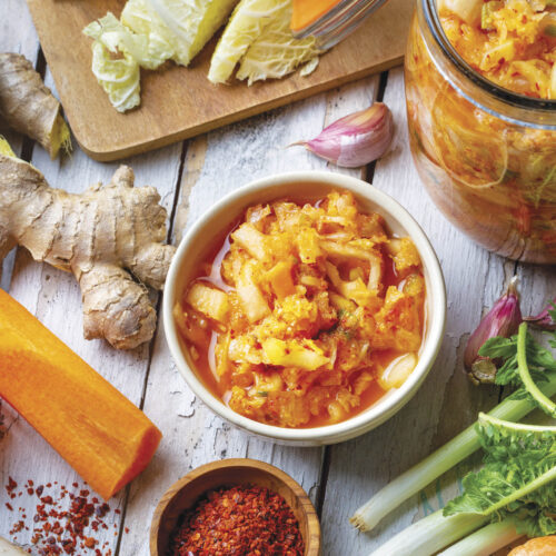 Ingredients to make kimchi and a bowl full of kimchi.