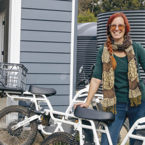 Kate with her electronic motorbike, which is solar charged.