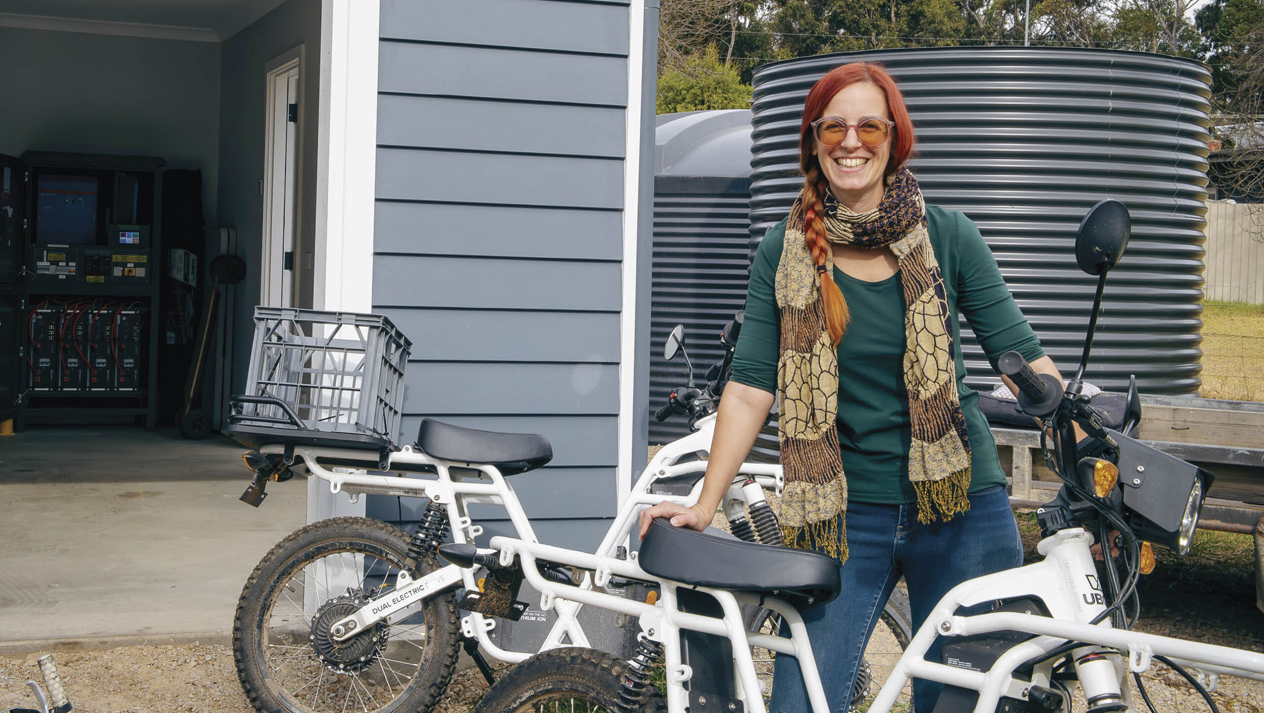 Kate with her electronic motorbike, which is solar charged.